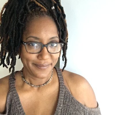 headshot of Trina with long braids and a gentle smile